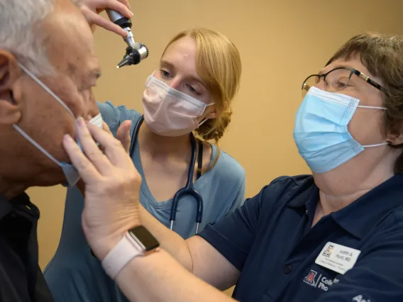 Dr Hunt examines a patient with a student