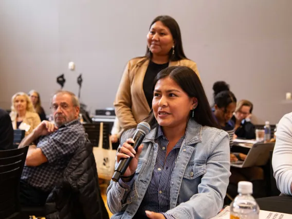 a woman holds a microphone to ask a question