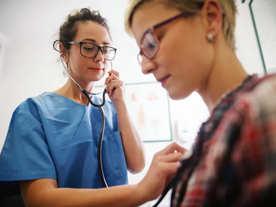 doctor listens to a patients heart with a stethoscope