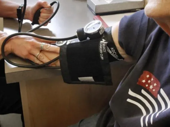 A Health worker takes a patients blood pressure