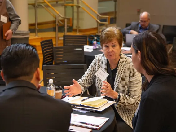 Vicki Buchda sits at a table with two others