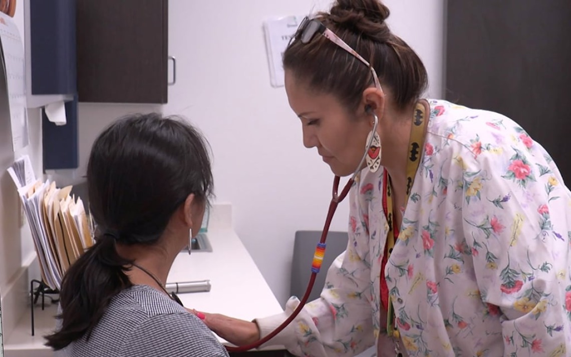 Nurse listens to patients heart with a stethoscope 