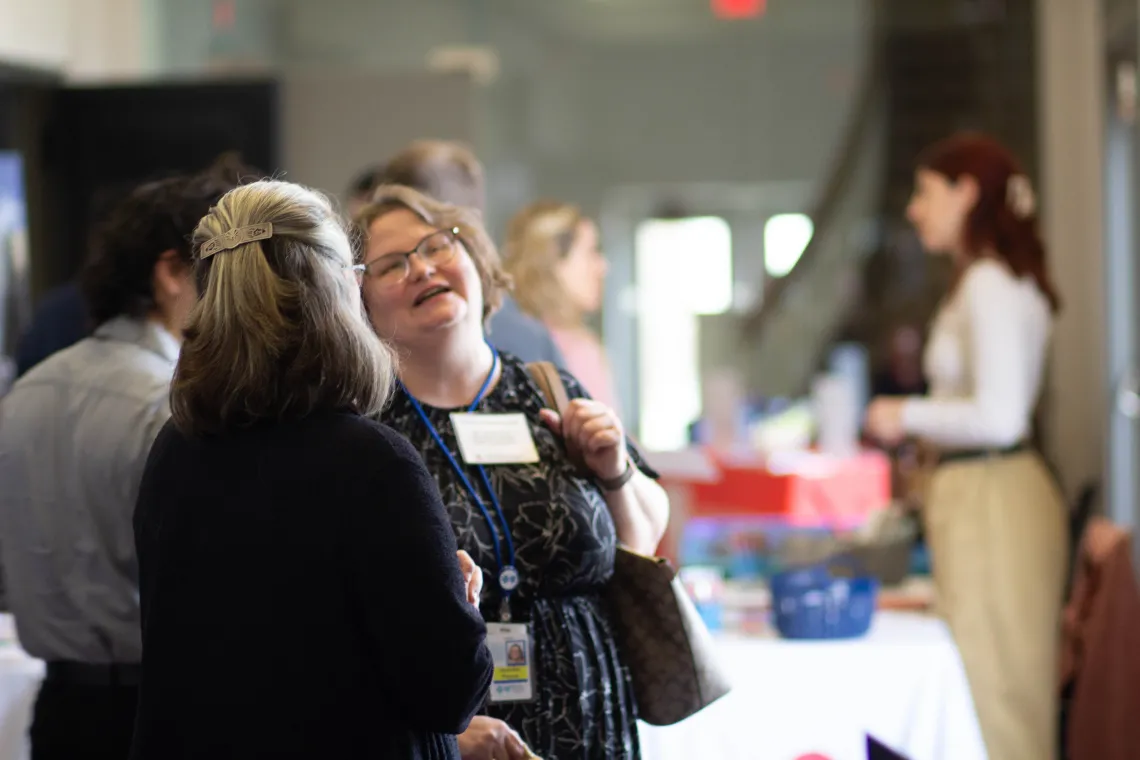 Attendees share a laugh with the vendor tables