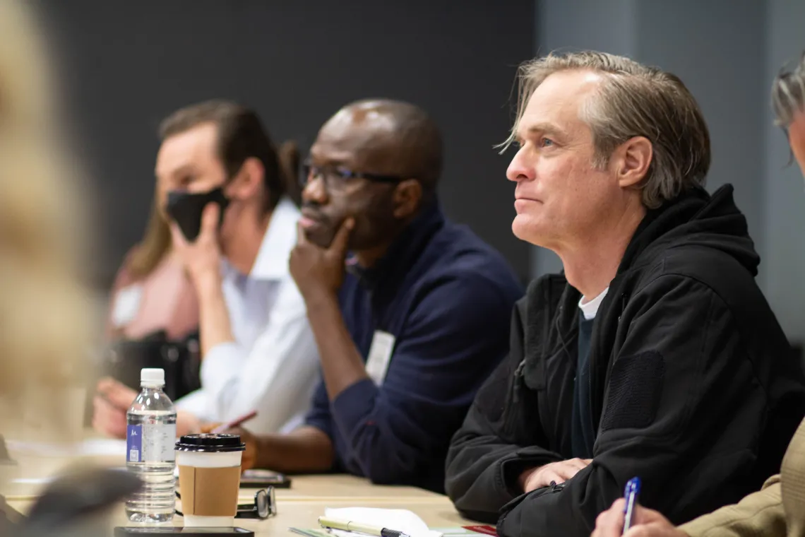 three men listening to a breakout session