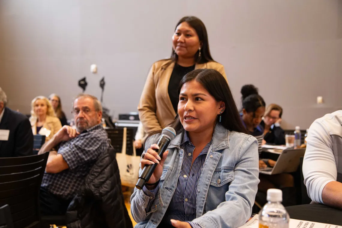 a woman holds a microphone to ask a question