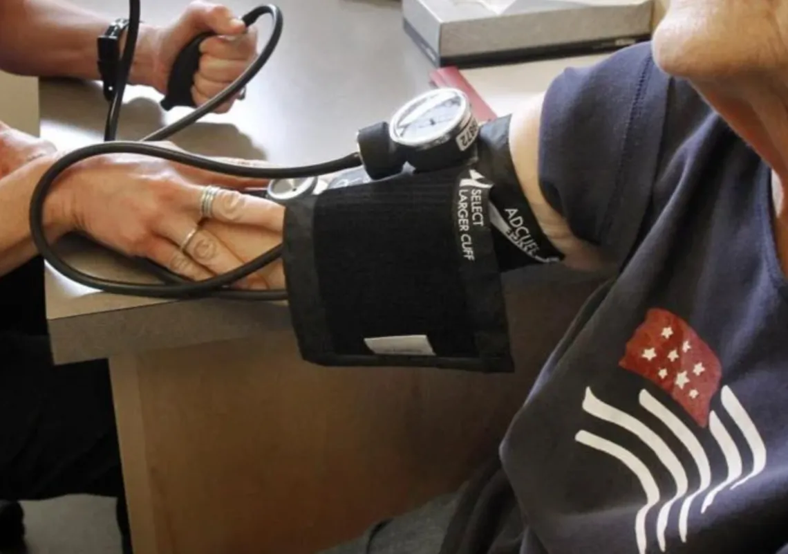 A Health worker takes a patients blood pressure