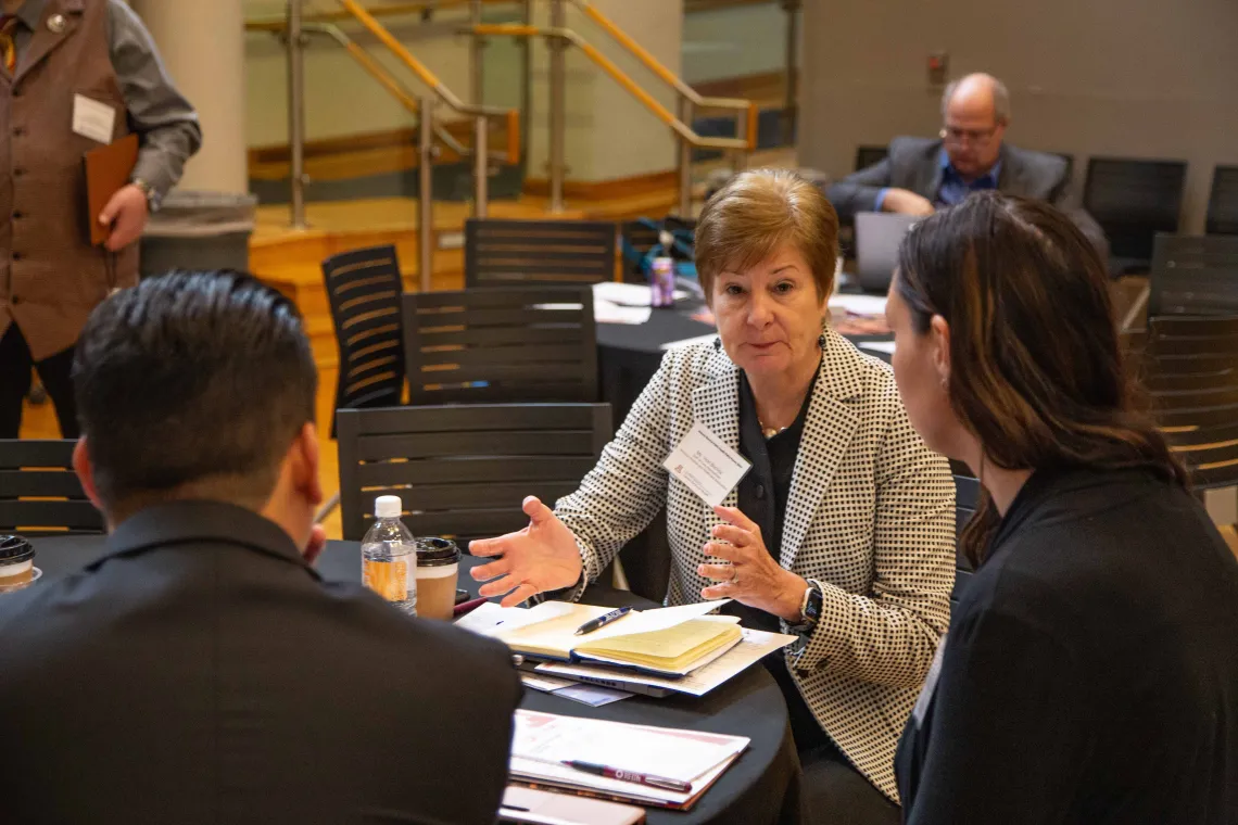 Vicki Buchda sits at a table with two others