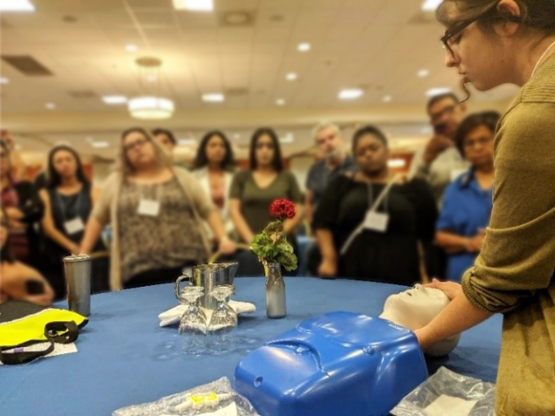 woman demonstrates naloxone administration with mannequin