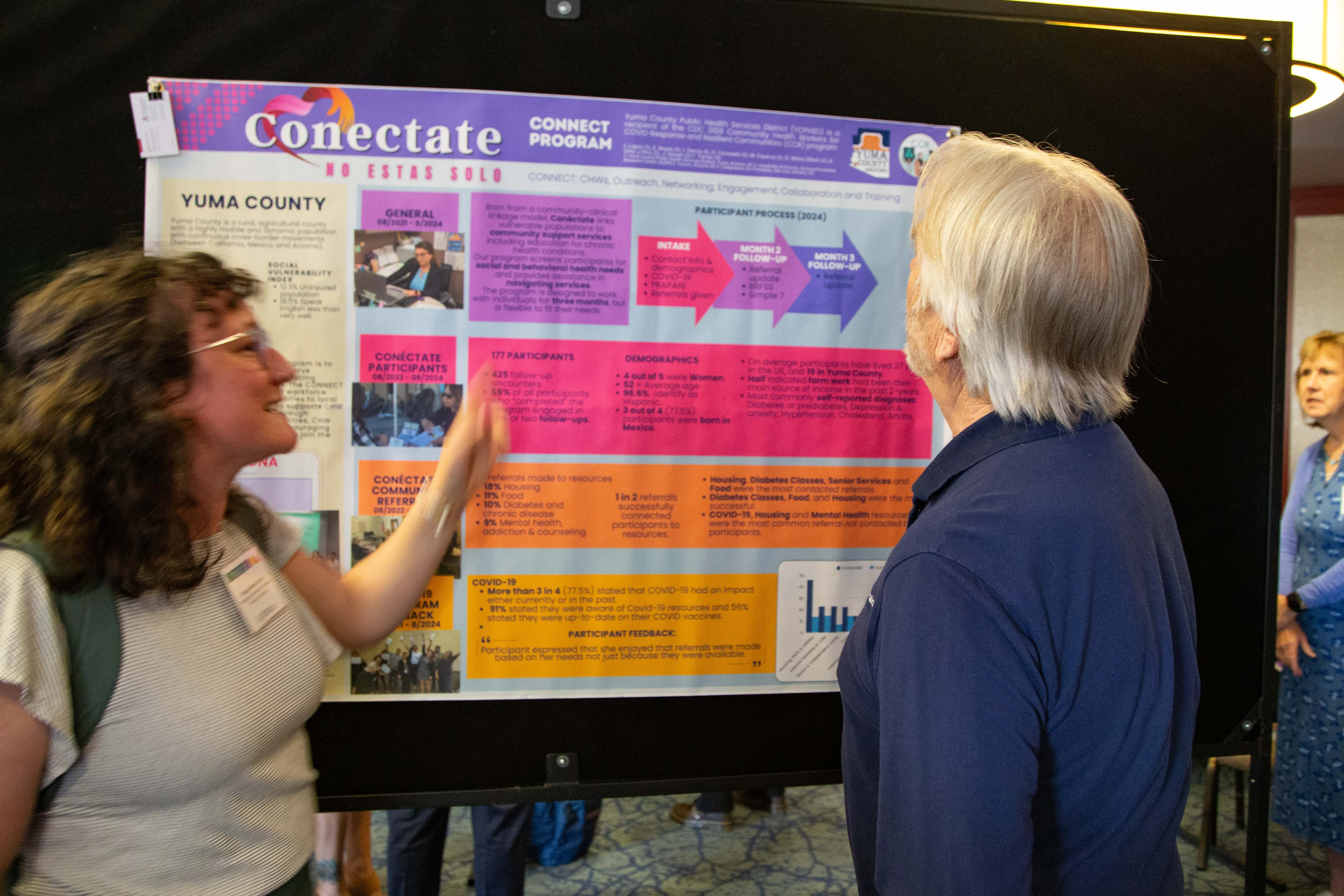 Georgia Weiss-Elliott presenting a poster to Dr. Derksen