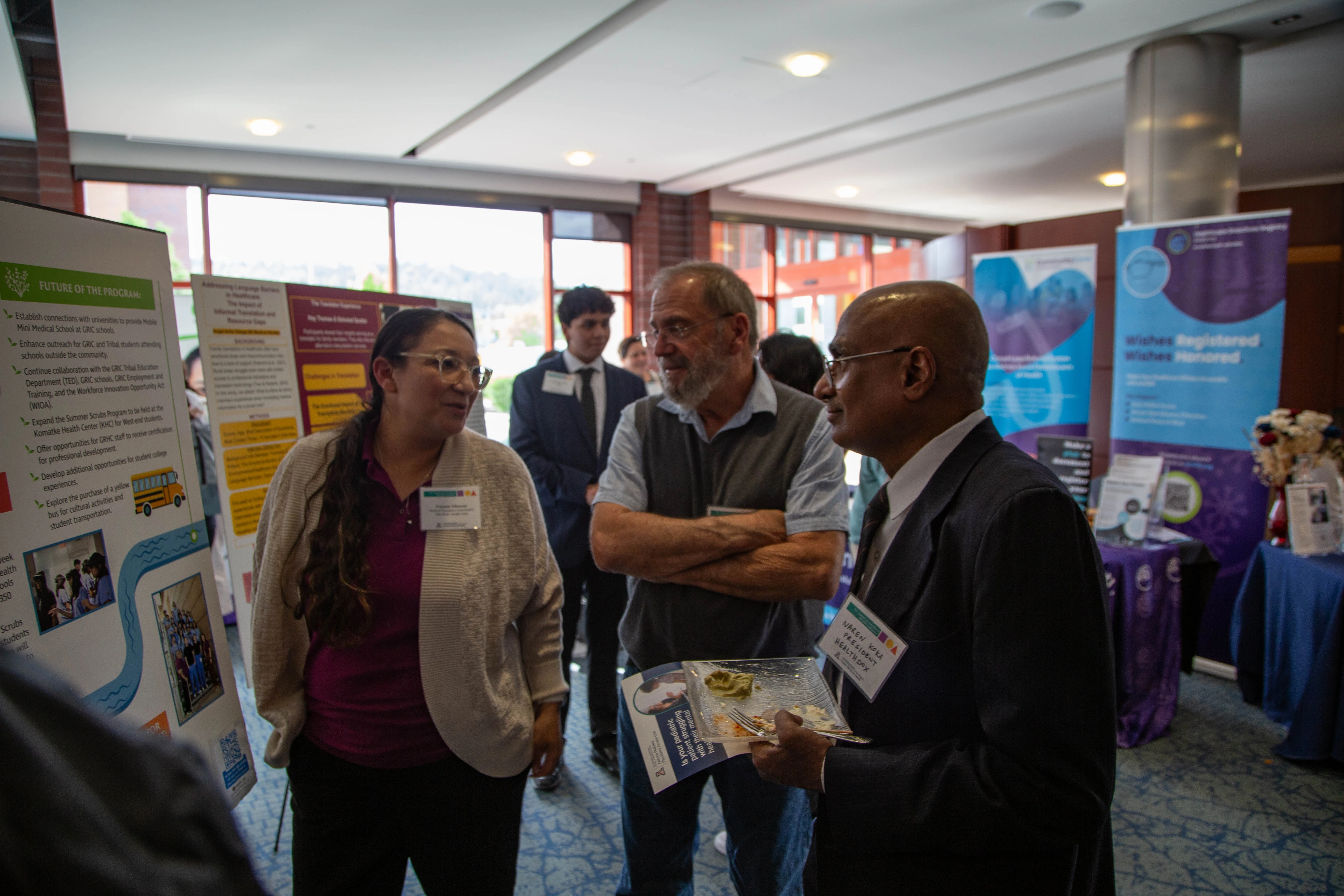 attendees discuss posters