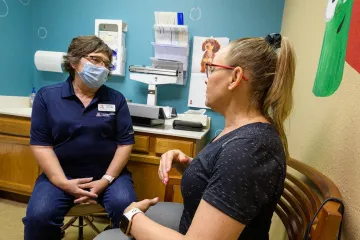 Dr. Hunt speaks with patient Tammy Walp in the clinic.