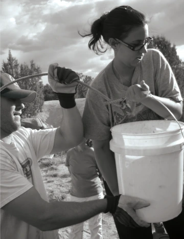 Service learning students carrying buckets