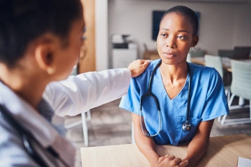 a doctor with their hand on another doctors shoulder